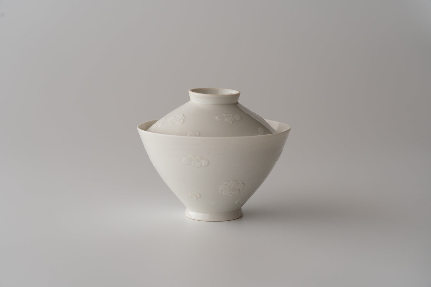 Kakiemon white porcelain bowl with embossed plum blossom design