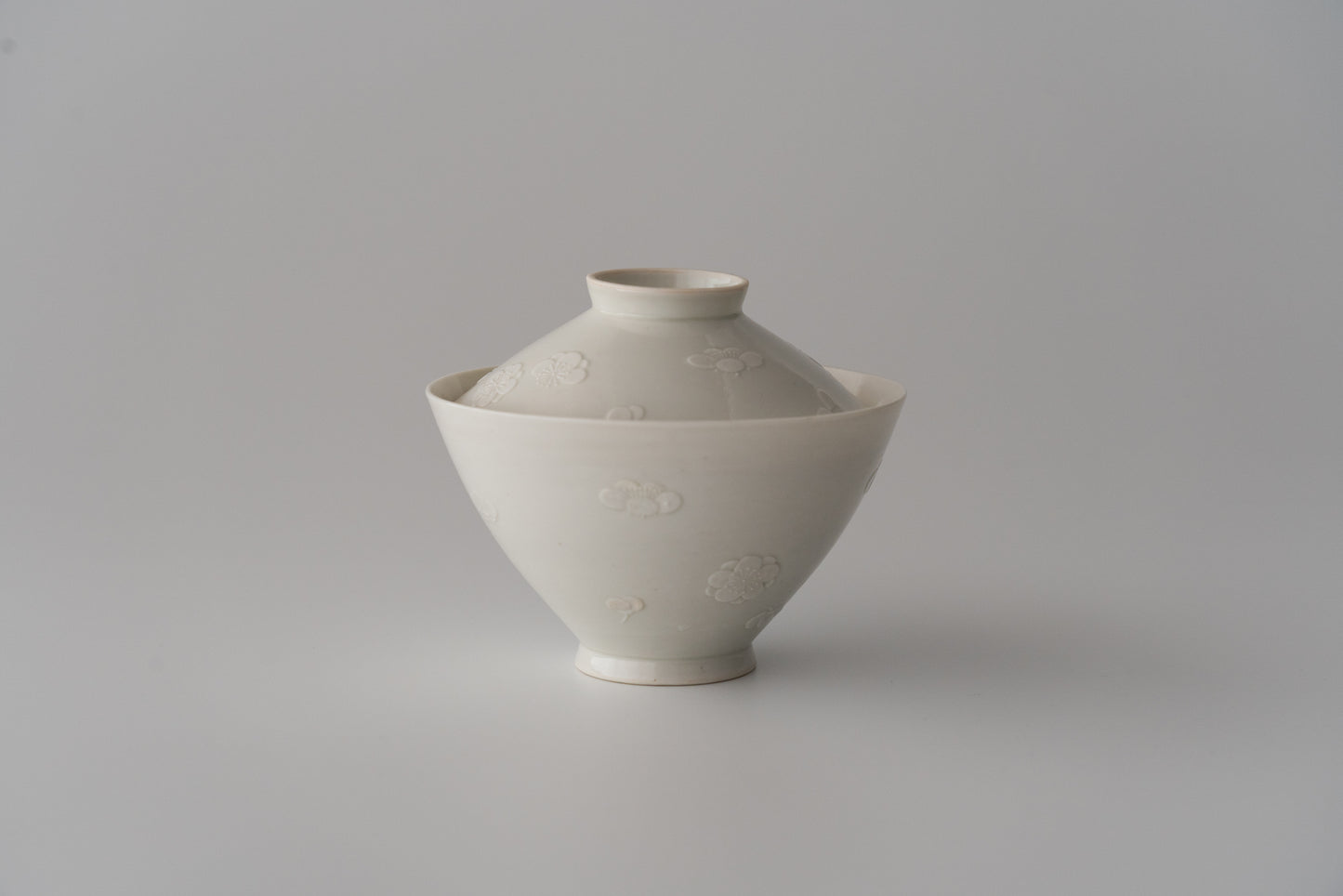 Kakiemon white porcelain bowl with embossed plum blossom design