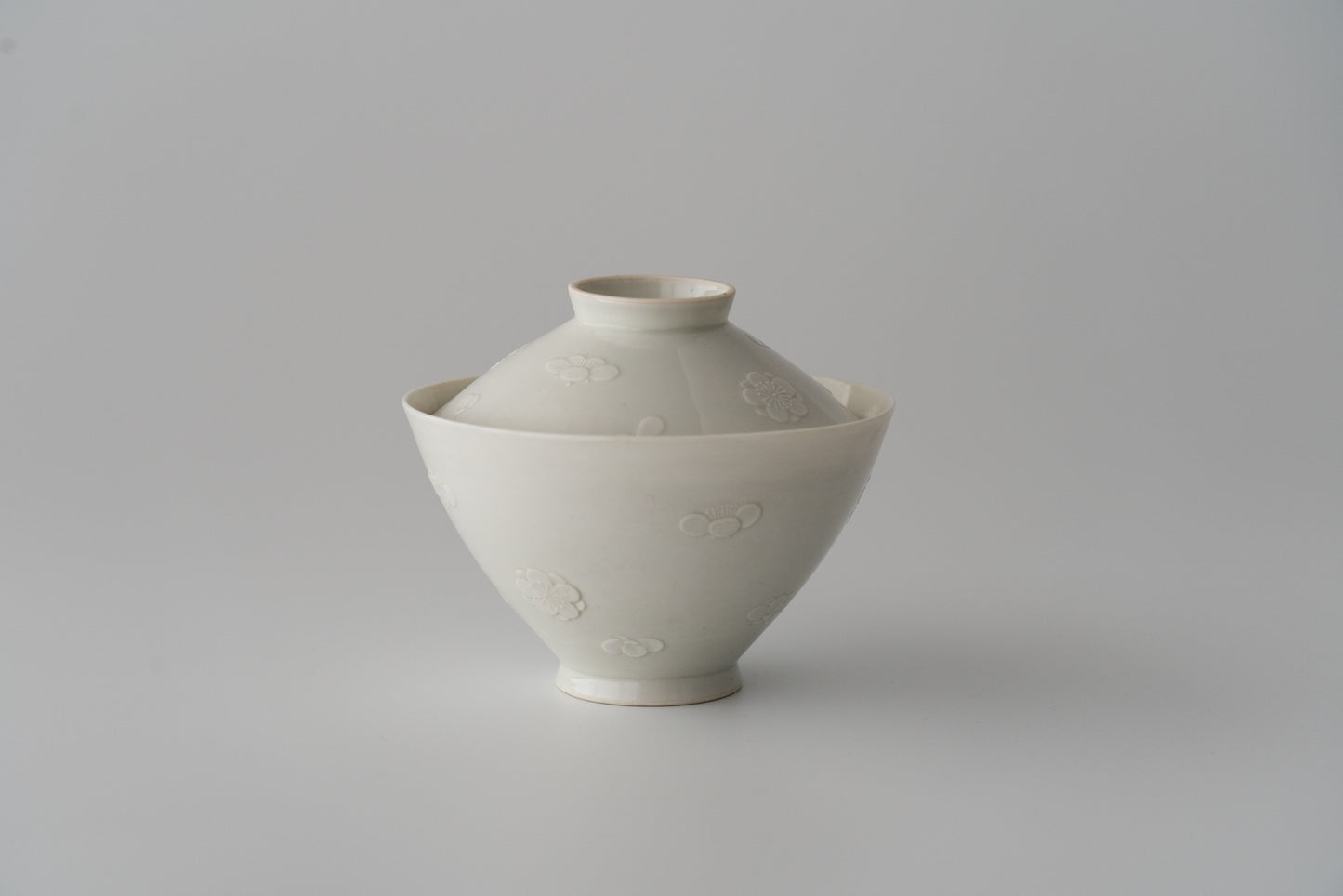 Kakiemon white porcelain bowl with embossed plum blossom design