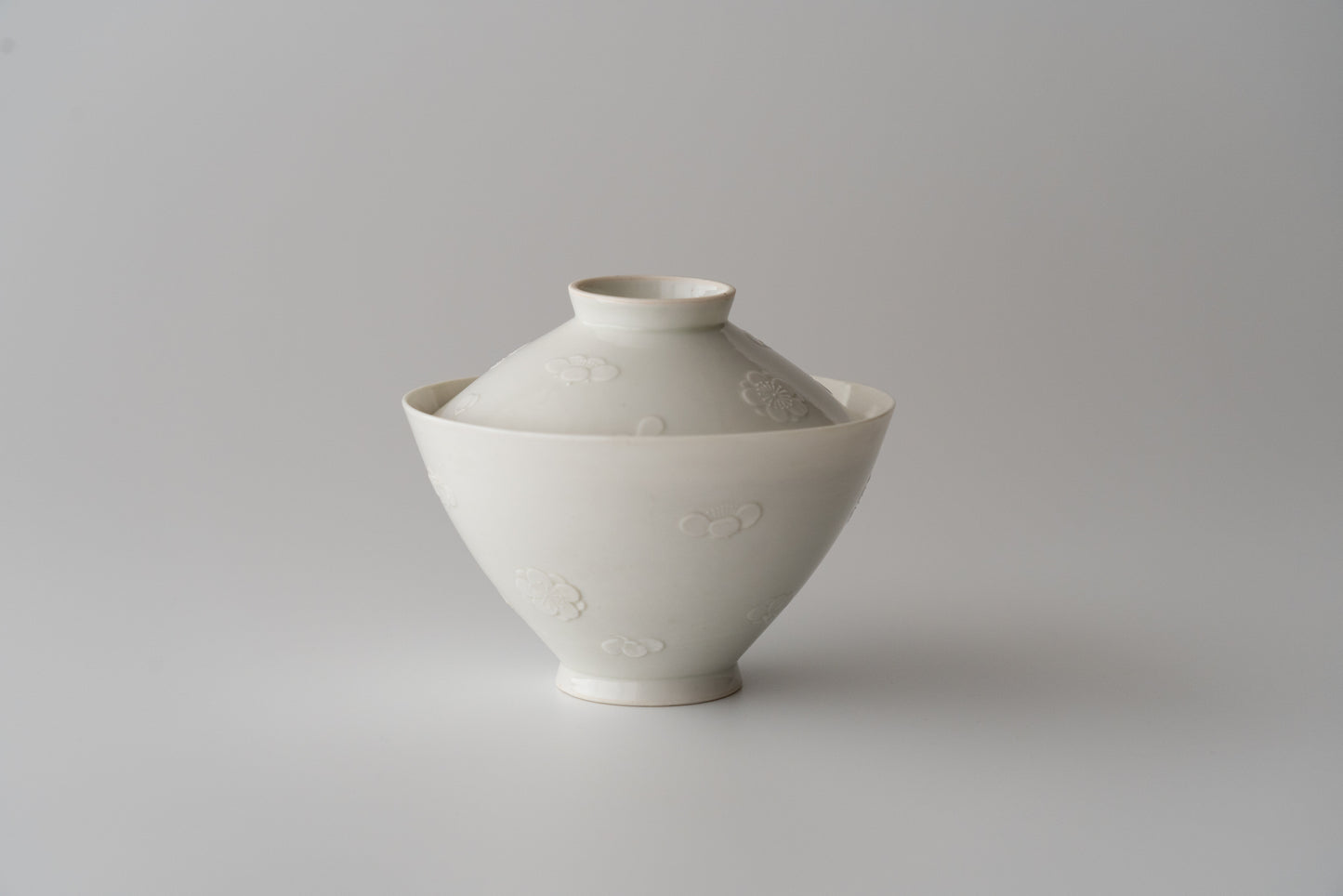 Kakiemon white porcelain bowl with embossed plum blossom design