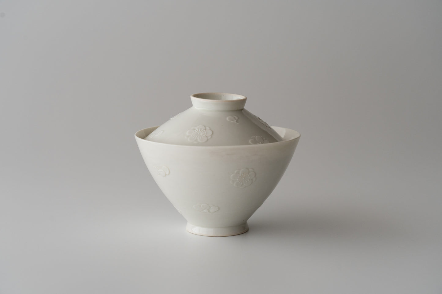 Kakiemon white porcelain bowl with embossed plum blossom design