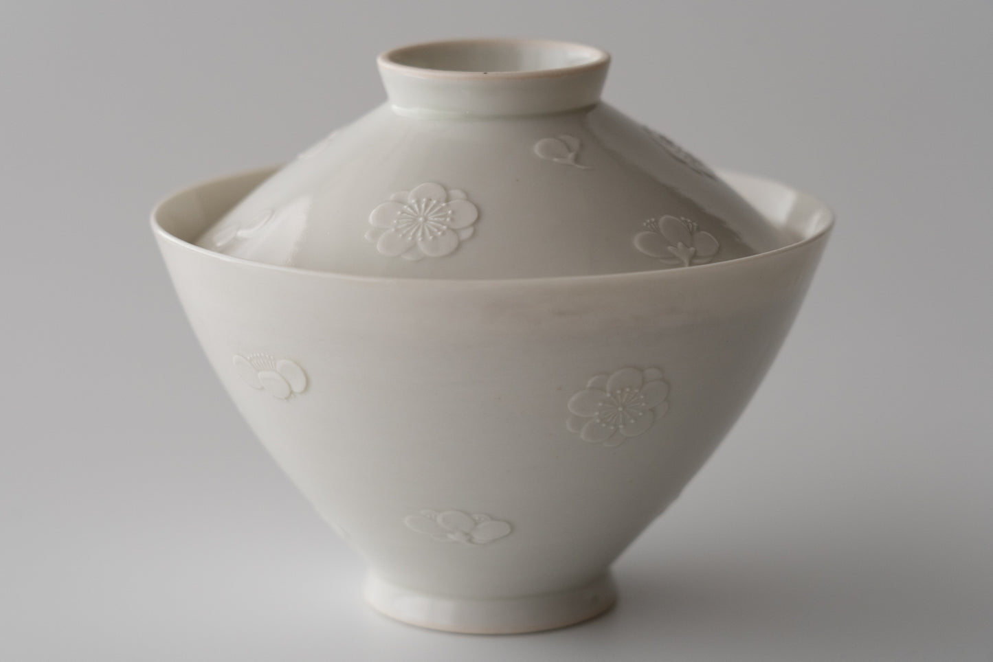 Kakiemon white porcelain bowl with embossed plum blossom design