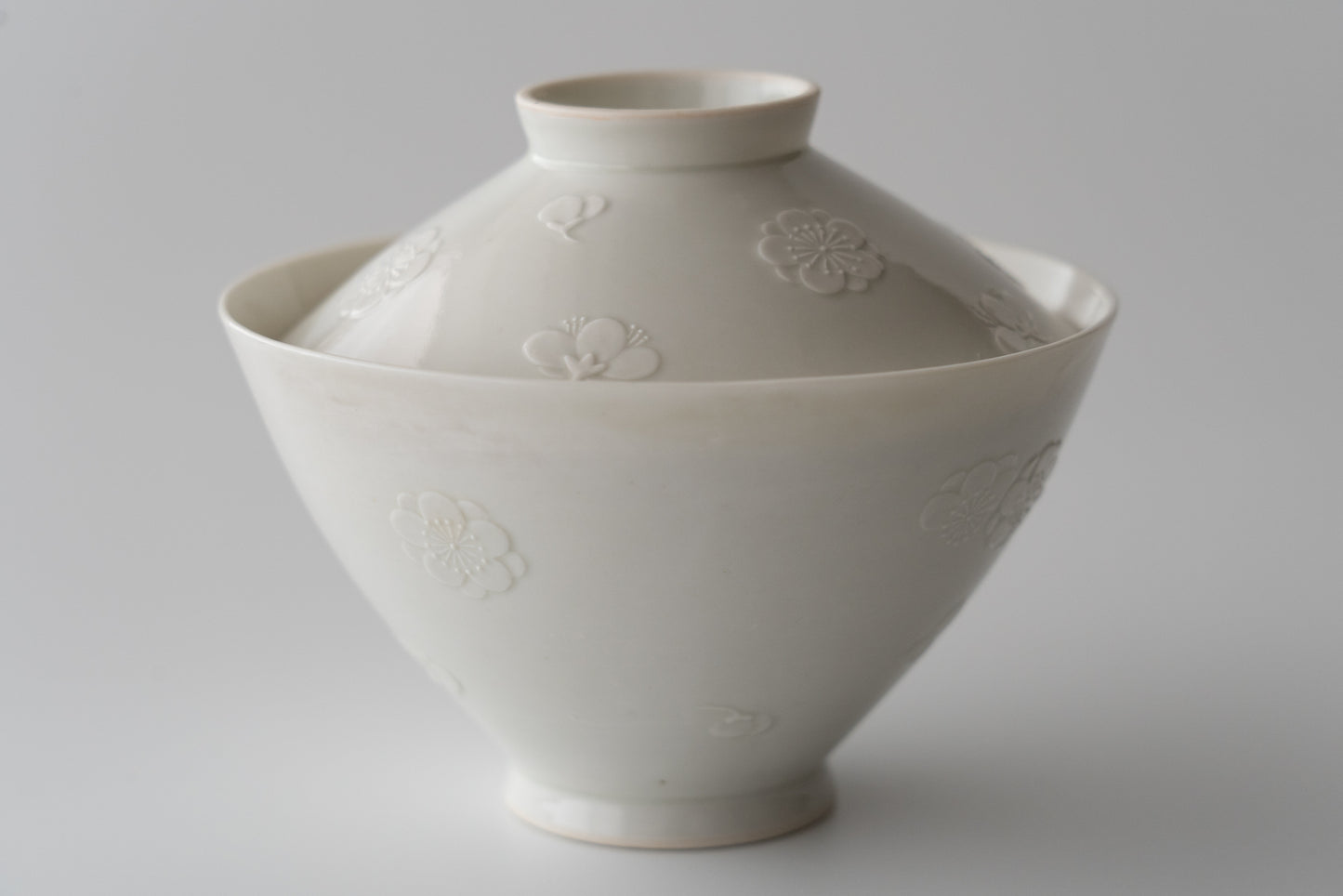 Kakiemon white porcelain bowl with embossed plum blossom design