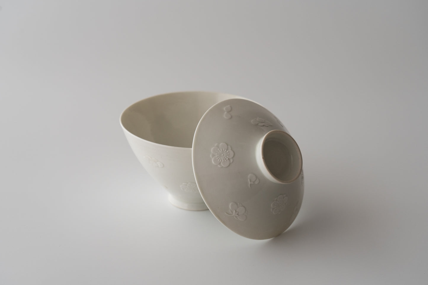 Kakiemon white porcelain bowl with embossed plum blossom design