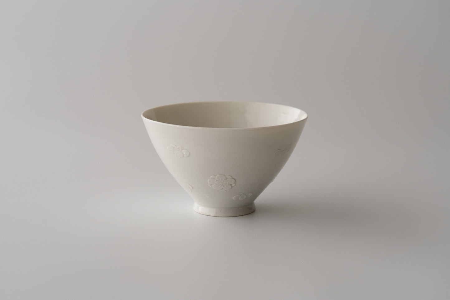 Kakiemon white porcelain bowl with embossed plum blossom design