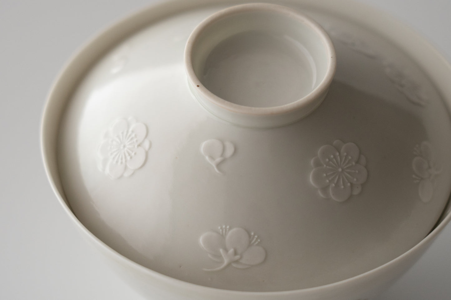 Kakiemon white porcelain bowl with embossed plum blossom design