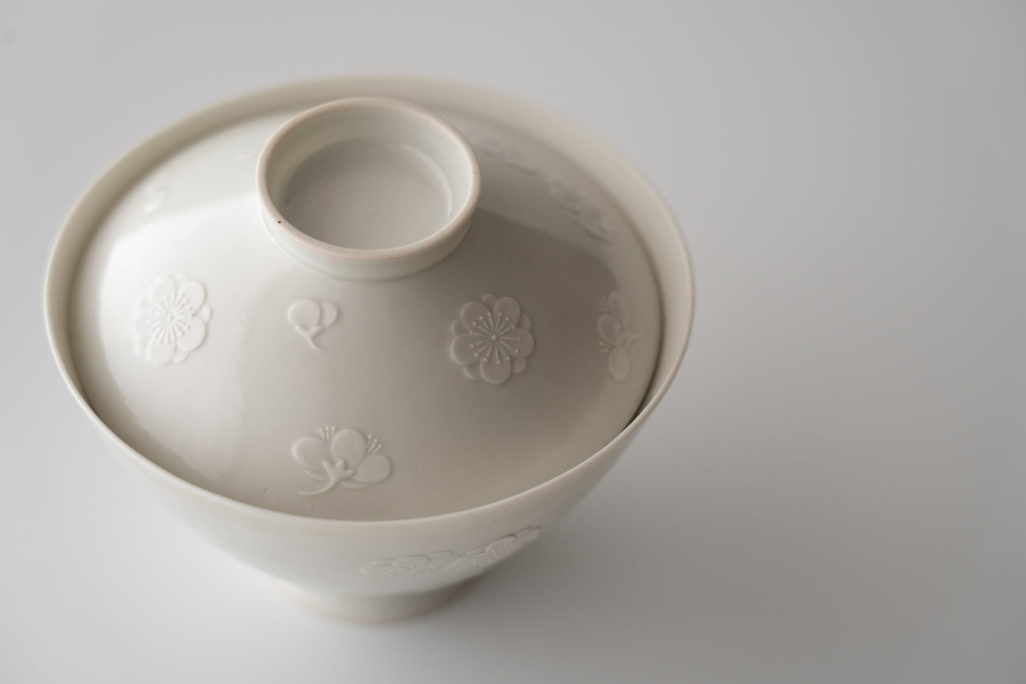 Kakiemon white porcelain bowl with embossed plum blossom design