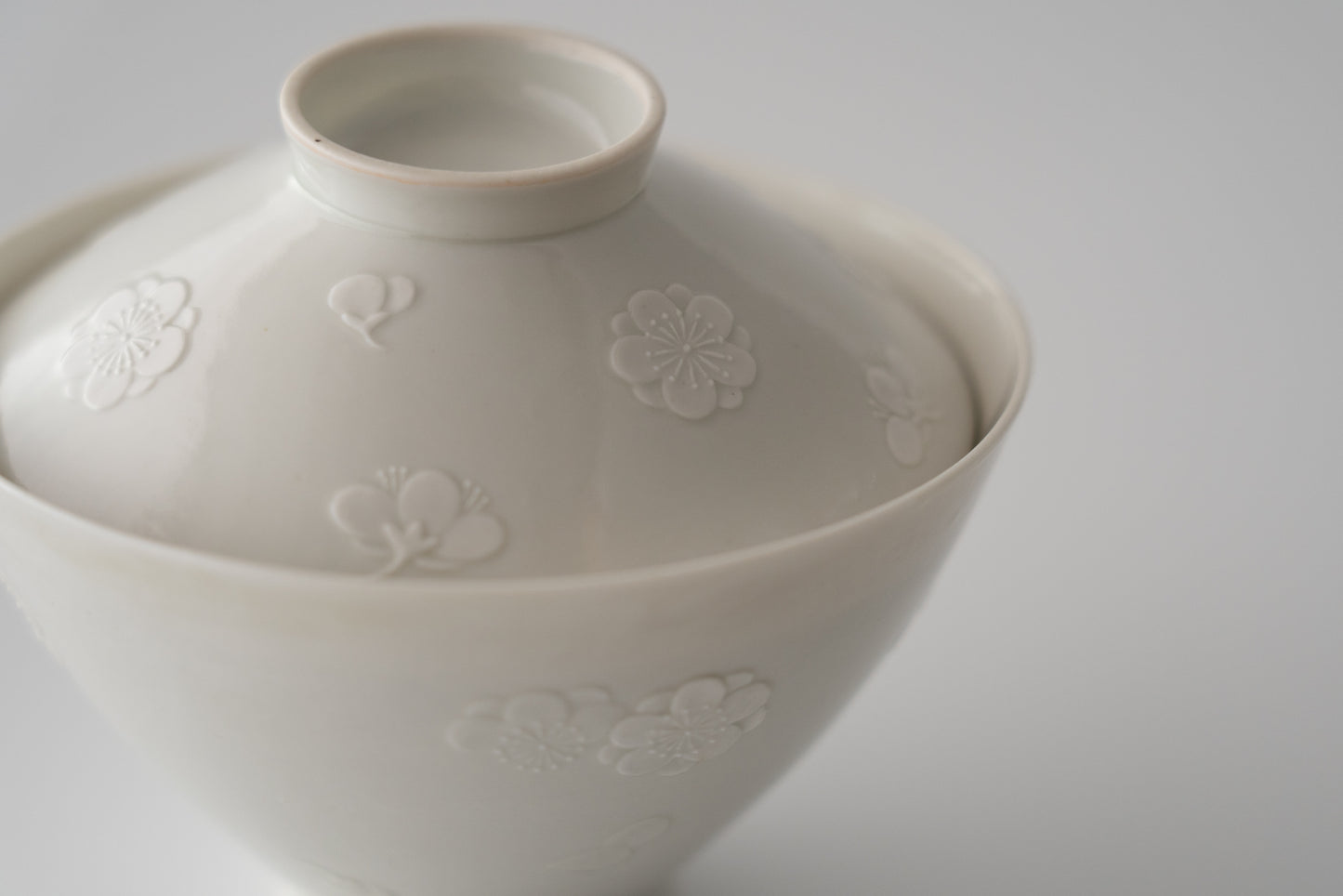 Kakiemon white porcelain bowl with embossed plum blossom design