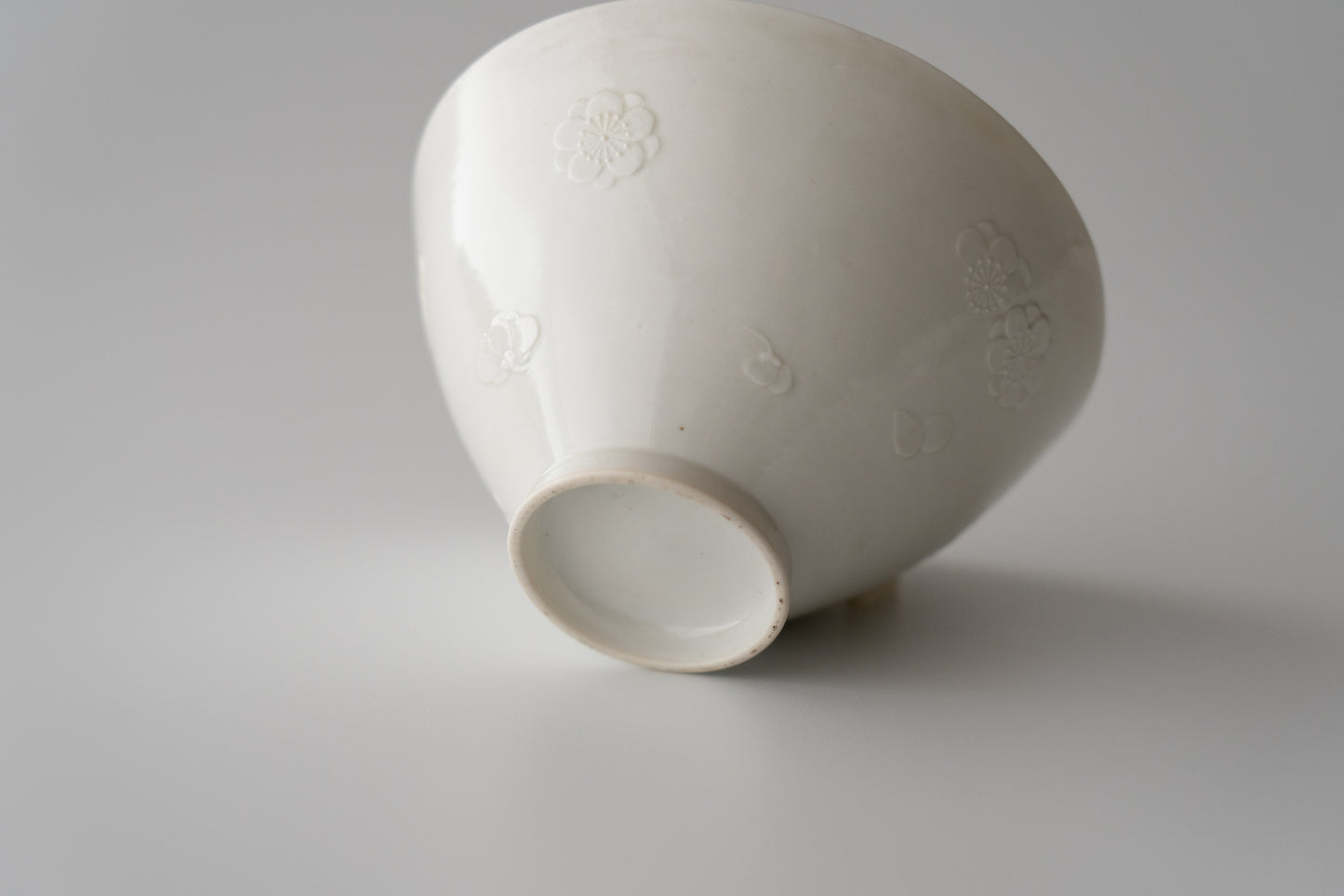 Kakiemon white porcelain bowl with embossed plum blossom design