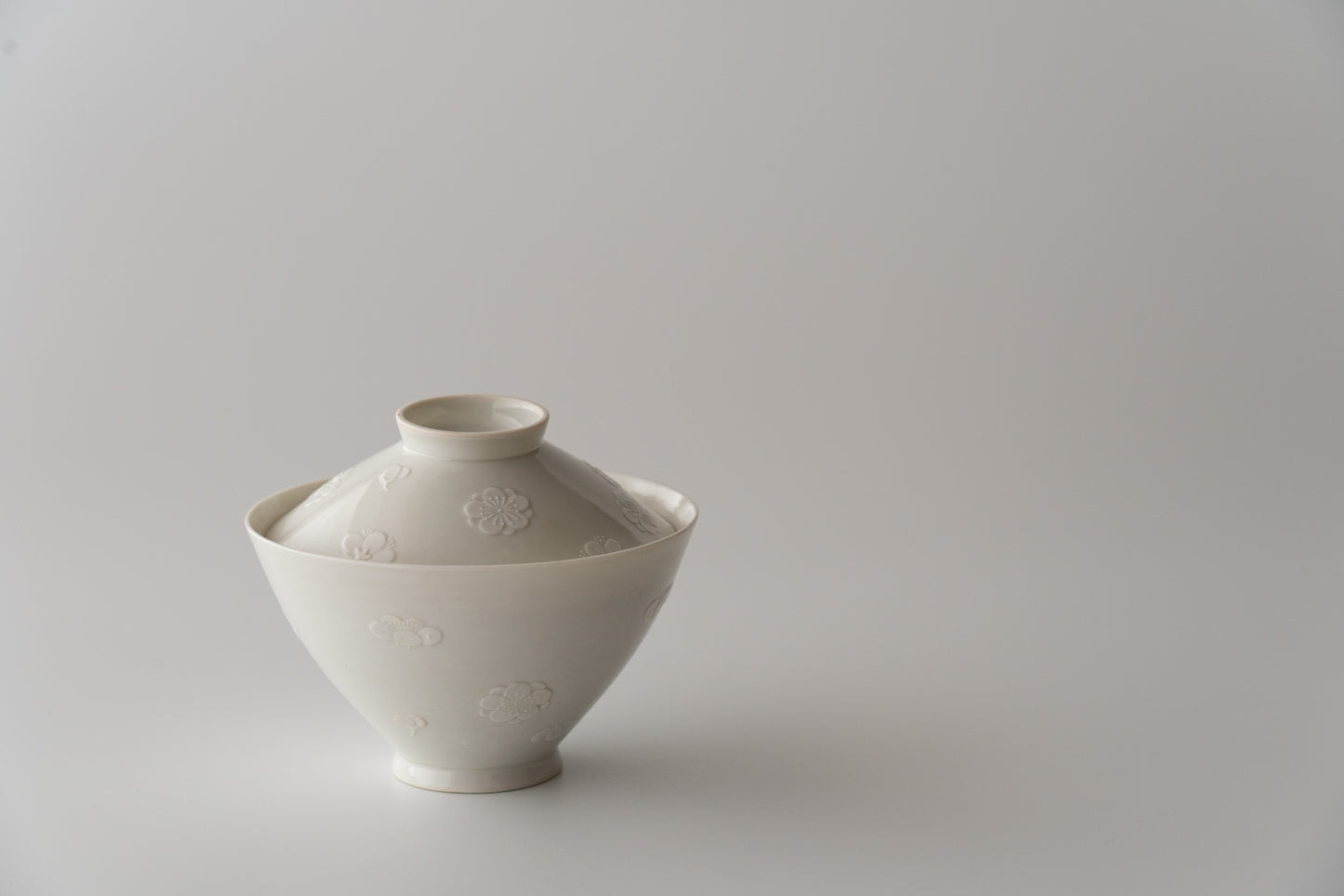 Kakiemon white porcelain bowl with embossed plum blossom design