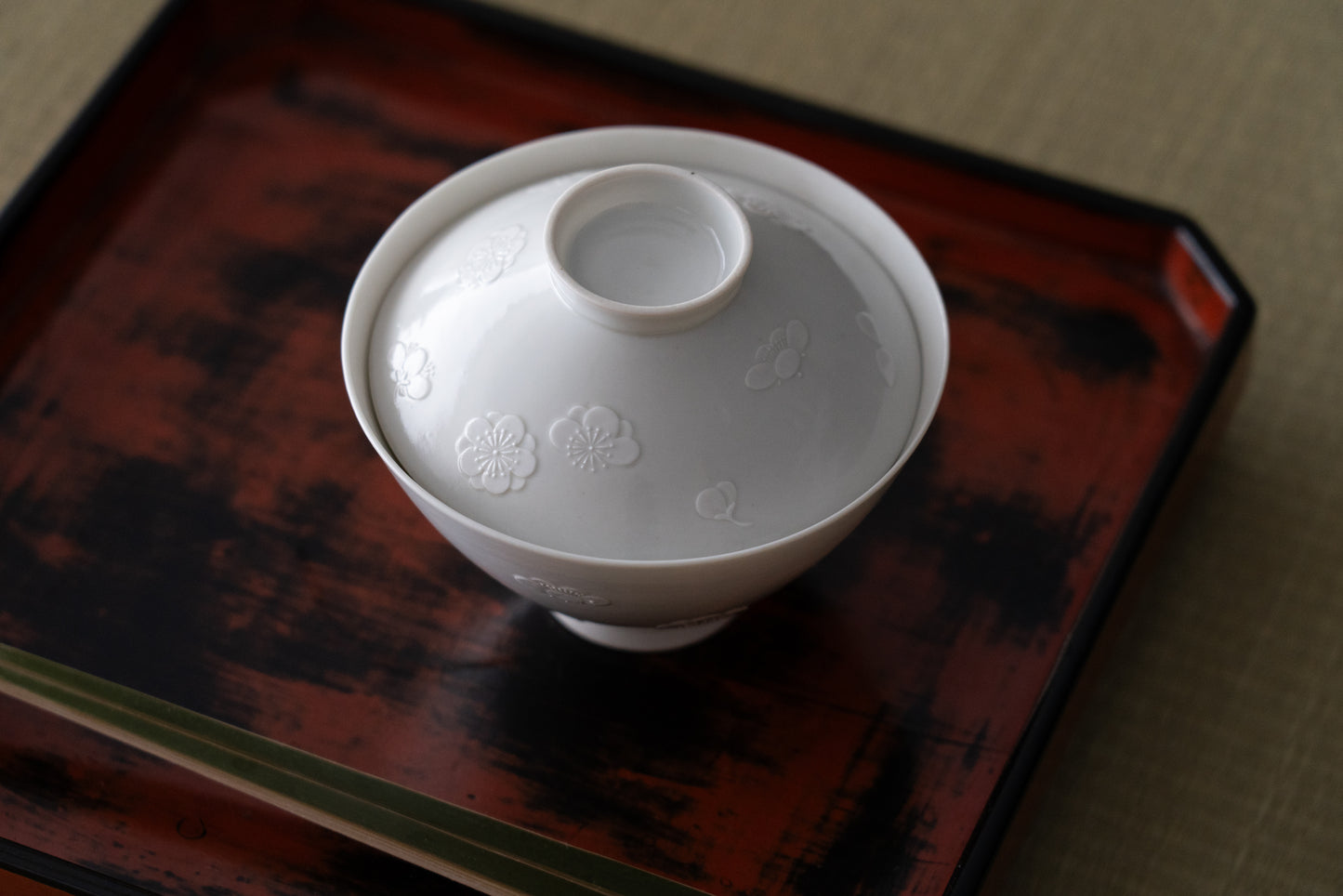 Kakiemon white porcelain bowl with embossed plum blossom design