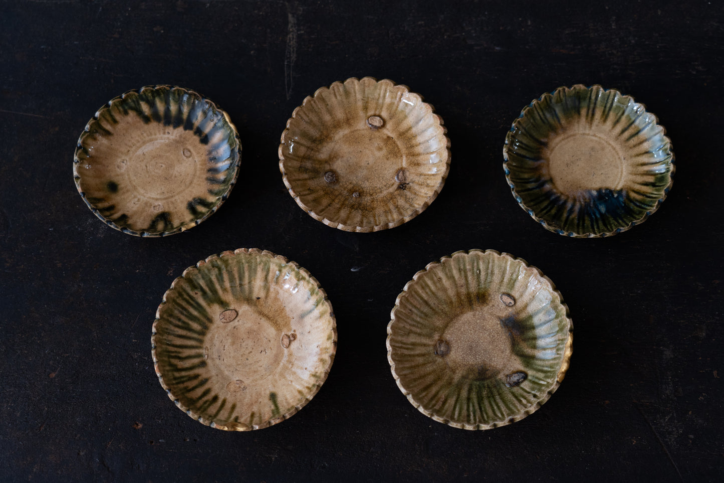 A set of five Oribe green glazed dishes in chrysanthemum design